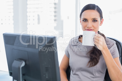 Relaxed attractive businesswoman drinking tea