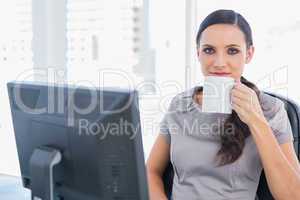 Relaxed attractive businesswoman drinking tea
