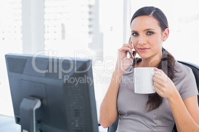 Relaxed businesswoman holding her coffee and phone