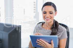 Cheerful attractive secretary scrolling on tablet pc