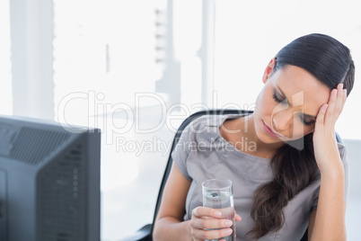 Attractive secretary with headache holding water