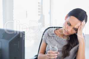 Attractive secretary with headache holding water