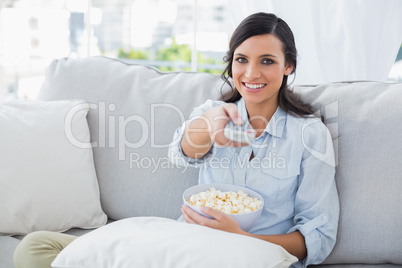 Pretty woman watching tv with popcorn