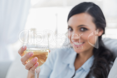 Attractive brunette offering white wine to camera