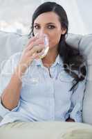 Attractive brunette drinking white wine