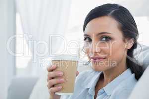 Seductive brunette holding coffee mug