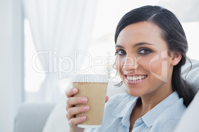 Smiling seductive brunette holding coffee mug