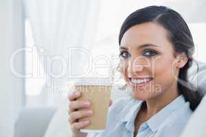 Smiling seductive brunette holding coffee mug