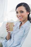 Cheerful seductive brunette holding coffee mug