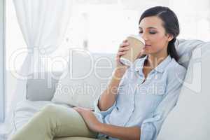 Happy seductive brunette drinking coffee