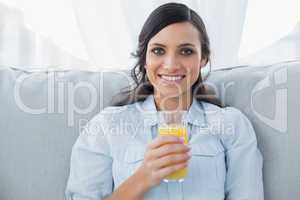 Cheerful brunette having orange juice