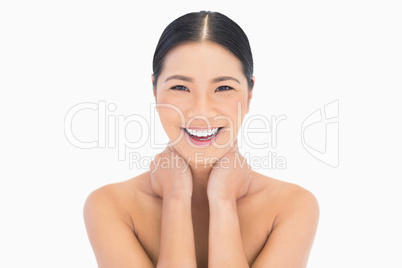 Cheerful natural model posing touching her neck