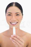 Cheerful gorgeous natural model holding chap stick