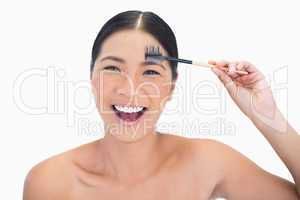 Laughing natural model using eyebrow brush