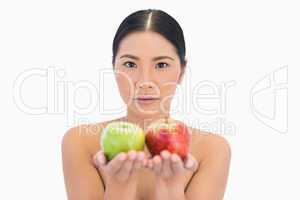 Content natural brunette holding apples in both hands