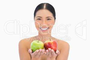 Cheerful natural brunette holding red and green apples
