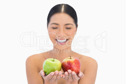 Happy natural brunette holding red and green apples