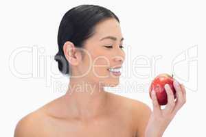 Smiling black haired model having red apple