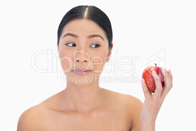 Curious black haired model having red apple