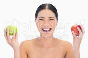 Happy black haired model holding apples in both hands