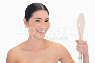 Smiling natural black haired model holding mirror