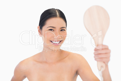 Cheerful dark haired young model holding mirror