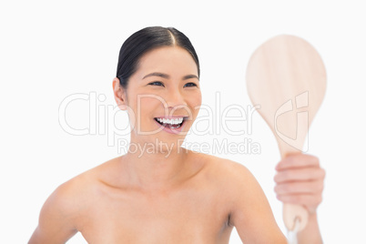Laughing dark haired young model looking at her reflection