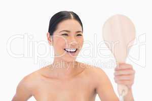 Laughing dark haired young model looking at her reflection