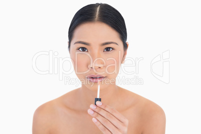 Serious beautiful model holding lip gloss