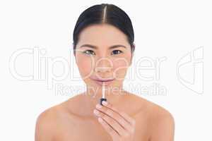 Content beautiful model holding lip gloss