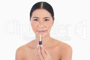 Peaceful attractive model holding lip gloss