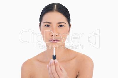 Calm attractive model holding lip gloss