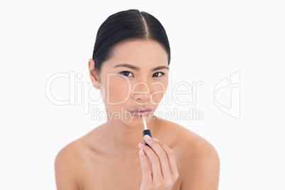 Sensual young model applying lip gloss