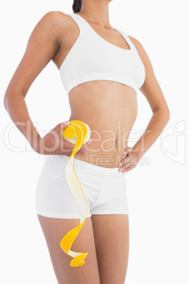 Female slender body in sport underwear holding peeled orange