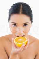 Pretty woman biting orange slice