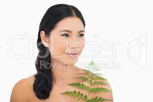 Relaxed dark haired woman with fern