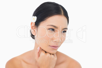 Thoughtful sensual model with white flower in her hair