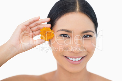 Happy sensual black haired model holding orange flower