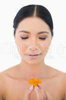Natural black haired model holding orange flower
