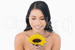 Smiling natural black haired model holding sunflower