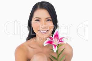 Smiling natural black haired model posing with lily