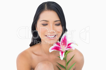 Cheerful natural black haired model posing with lily