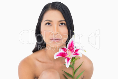 Pensive natural black haired model posing with lily