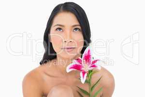 Pensive natural black haired model posing with lily