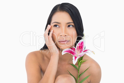 Natural model posing with lily and touching her face