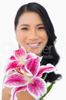 Cheerful natural brown haired model posing with lily
