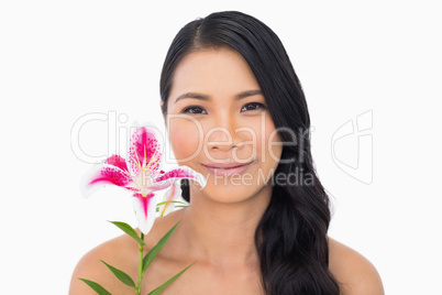 Peaceful natural brown haired model holding lily
