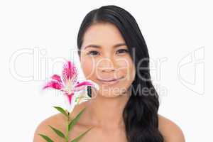 Peaceful natural brown haired model holding lily