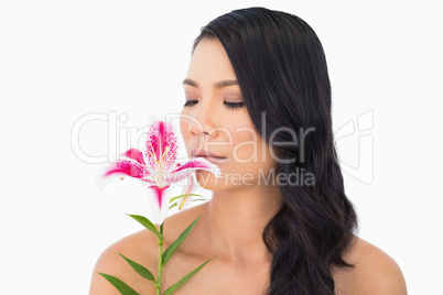 Natural brown haired model smelling lily