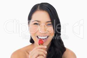 Gorgeous brown haired model eating strawberry